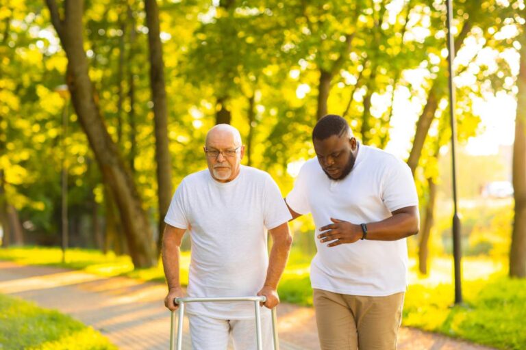 A caregiver helping an older adult with daily activities in a cozy living room setting.