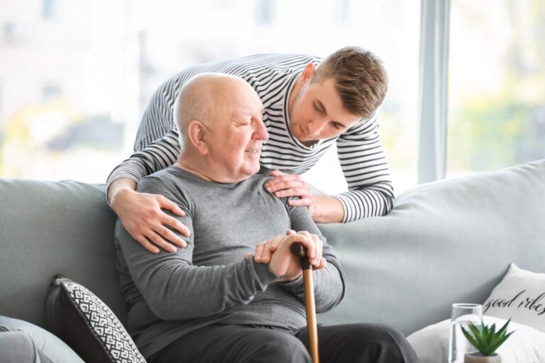 Older adult reviewing a medication reminder beside a tablet and motion-activated hallway light.